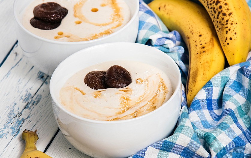 Tavolo con bowl di porridge, banane e tovaglia a quadrati